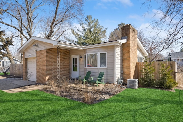 view of property exterior with a yard, a chimney, an attached garage, and fence