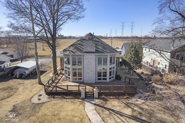 view of front facade featuring a chimney and a wooden deck