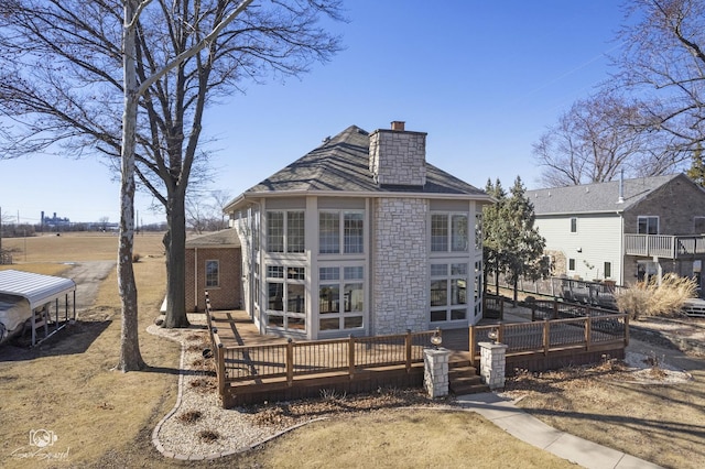 back of property featuring a deck and a chimney