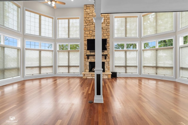 8043 Tamarack Ln, Morris, IL 60450 - unfurnished living room featuring a ceiling fan, a high ceiling, a fireplace, and healthy amount of natural light