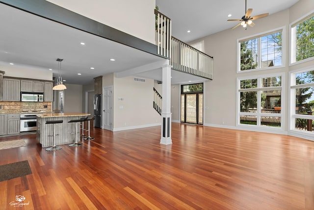 8043 Tamarack Ln, Morris, IL 60450 - living area featuring wood finished floors, a ceiling fan, recessed lighting, a high ceiling, and stairway