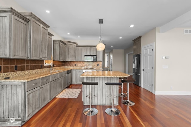 8043 Tamarack Ln, Morris, IL 60450 - kitchen with stainless steel appliances, dark wood finished floors, tasteful backsplash, gray cabinets, and a kitchen island