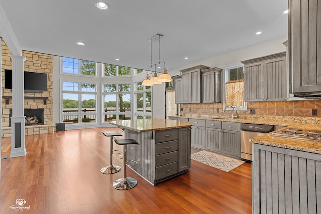 8043 Tamarack Ln, Morris, IL 60450 - kitchen featuring appliances with stainless steel finishes, gray cabinetry, dark wood-style floors, light stone counters, and a kitchen island
