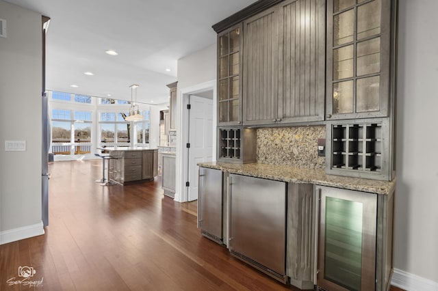 kitchen featuring high end fridge, wine cooler, dark wood-style flooring, and decorative backsplash