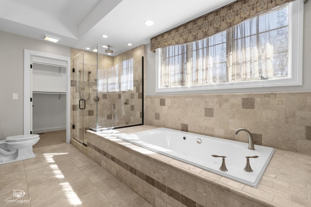 full bath featuring a walk in closet, a garden tub, recessed lighting, toilet, and a stall shower