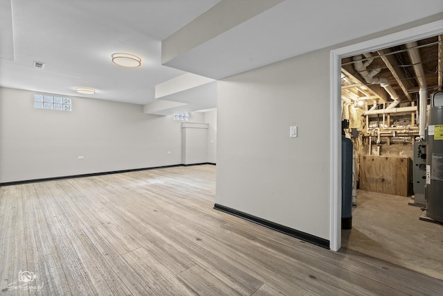 below grade area featuring visible vents, baseboards, and wood finished floors