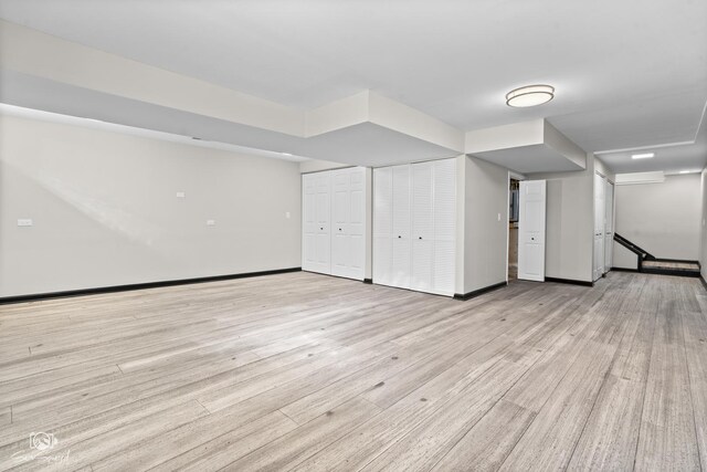 finished basement featuring light wood-style flooring and baseboards