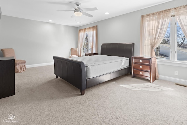 bedroom with light carpet, recessed lighting, visible vents, and baseboards