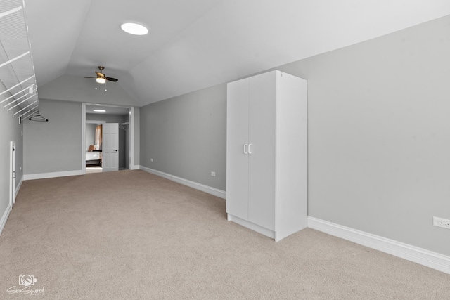 additional living space with light carpet, baseboards, a ceiling fan, and lofted ceiling