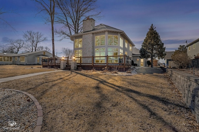 view of front of house with a chimney and a wooden deck