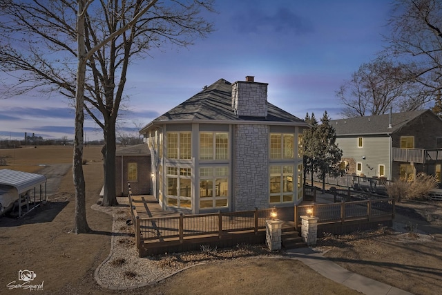 rear view of property with a deck and a chimney