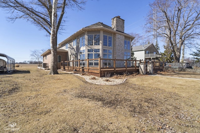 rear view of property with a deck and a chimney