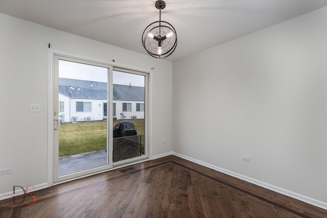 unfurnished room featuring baseboards, visible vents, a chandelier, and dark wood-style flooring