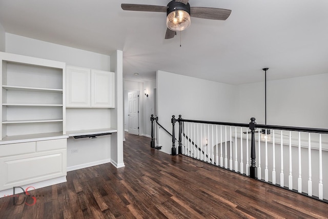 interior space featuring dark wood-style floors, ceiling fan, and baseboards