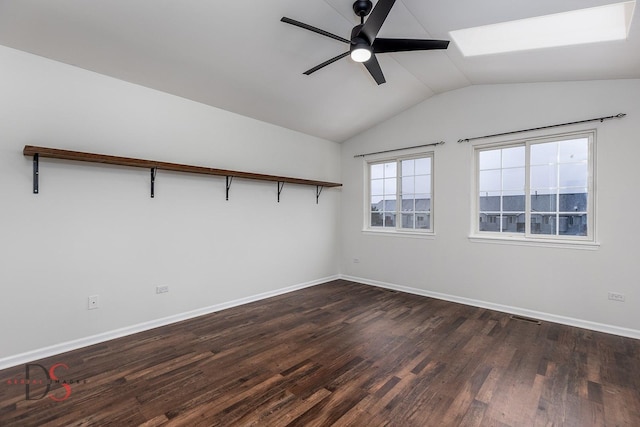 unfurnished room featuring lofted ceiling with skylight, baseboards, a ceiling fan, and dark wood-style flooring