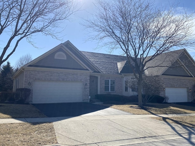 single story home with a garage, brick siding, and aphalt driveway