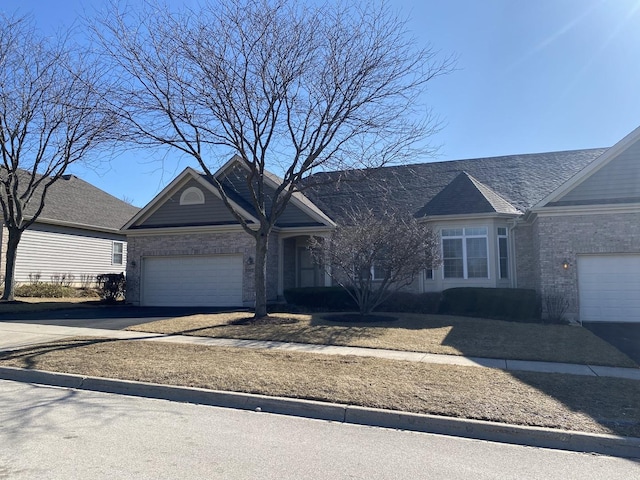 ranch-style home featuring driveway, brick siding, and an attached garage