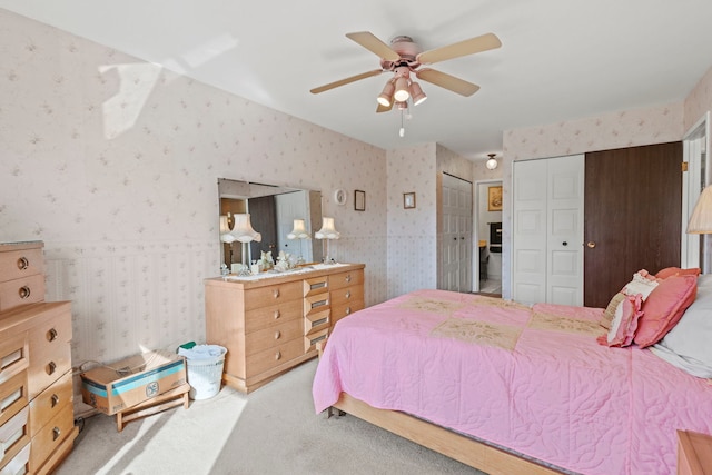 bedroom with multiple closets, wallpapered walls, carpet, and a ceiling fan