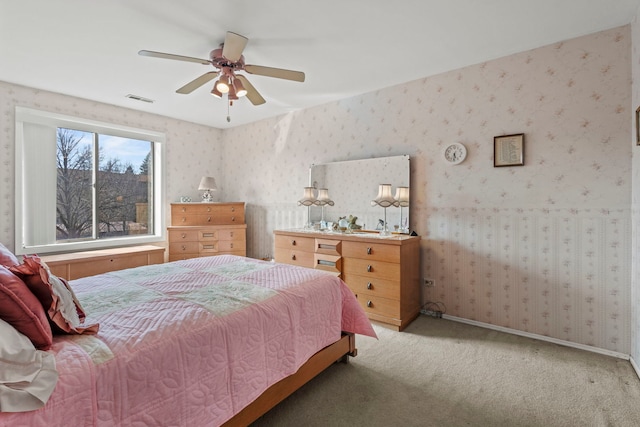 bedroom featuring a ceiling fan, baseboards, visible vents, wallpapered walls, and carpet flooring