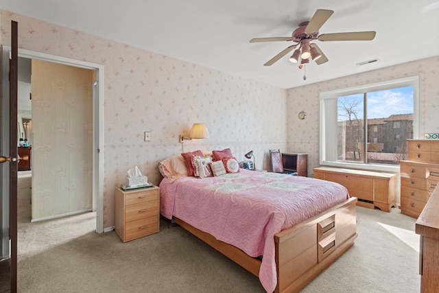 bedroom featuring wallpapered walls, light colored carpet, and visible vents