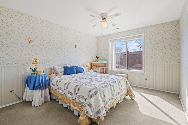 bedroom featuring visible vents, a ceiling fan, carpet, wallpapered walls, and baseboards