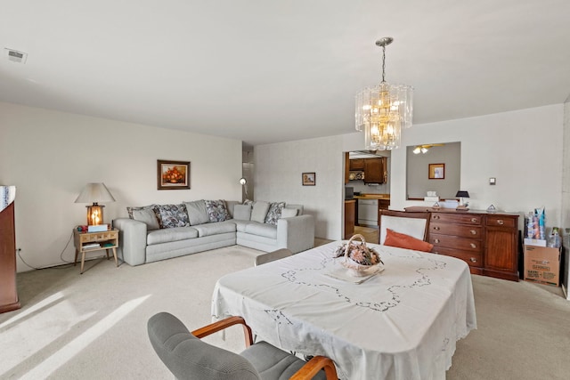 dining room featuring visible vents, light colored carpet, and a chandelier