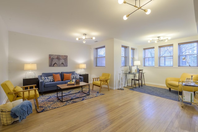 living room with a notable chandelier, baseboards, and wood-type flooring