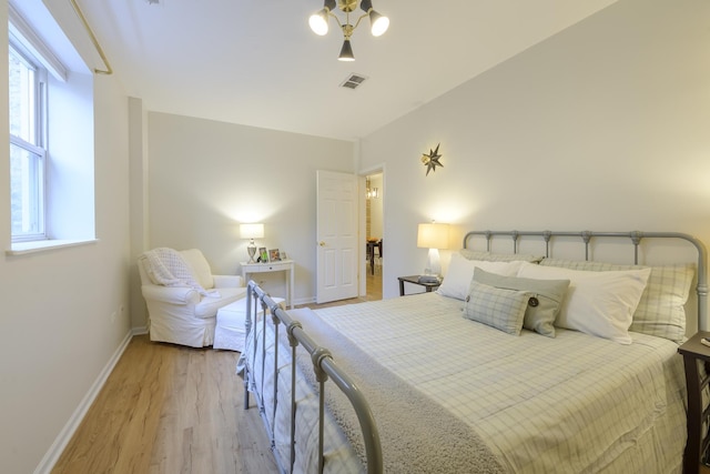 bedroom with baseboards, visible vents, and light wood-type flooring