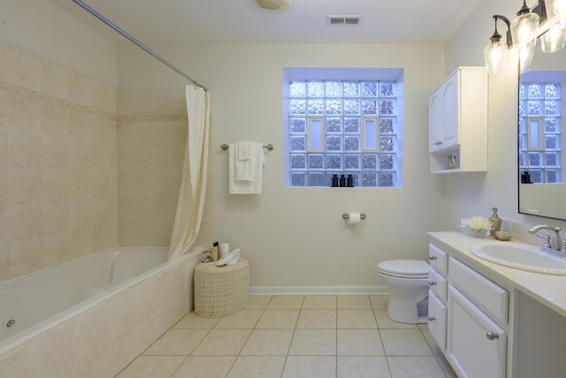 bathroom featuring vanity, visible vents, tile patterned flooring, toilet, and tiled shower / bath