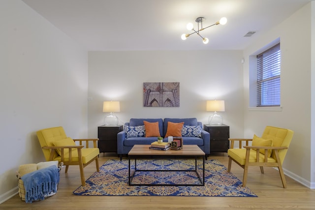 living room featuring visible vents, baseboards, and wood finished floors