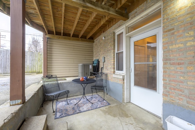 view of patio with central air condition unit and fence