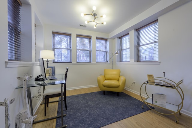 office featuring visible vents, baseboards, wood finished floors, and a chandelier