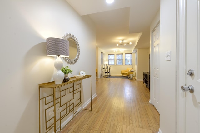 hallway featuring light wood-style floors and baseboards