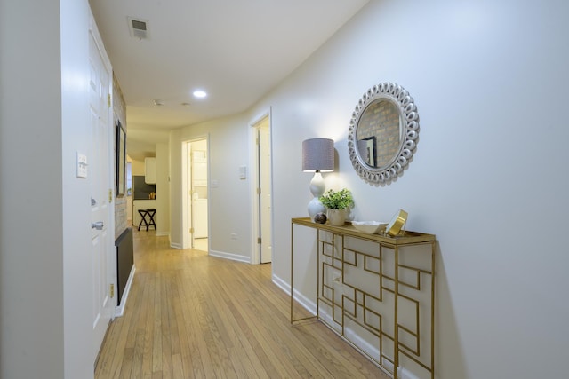 hallway featuring recessed lighting, visible vents, baseboards, and light wood-style flooring