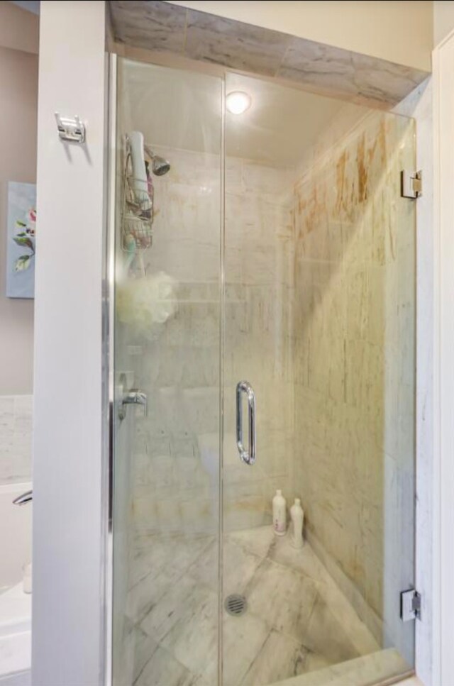 bathroom featuring a marble finish shower