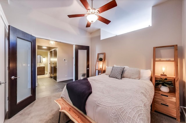 carpeted bedroom featuring baseboards, ensuite bath, and ceiling fan