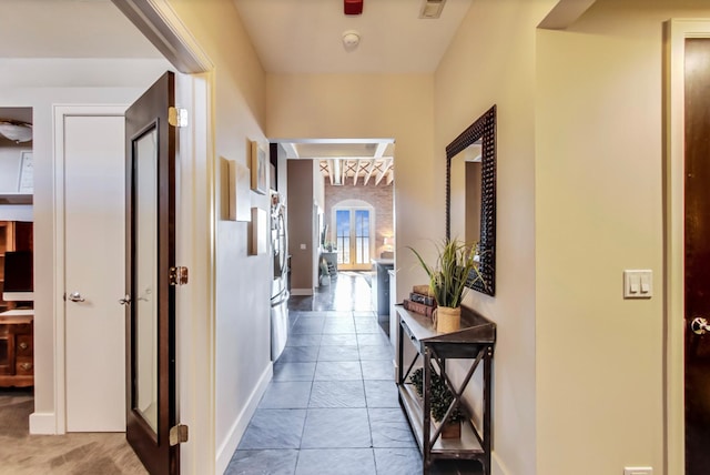 hall featuring arched walkways, visible vents, and baseboards