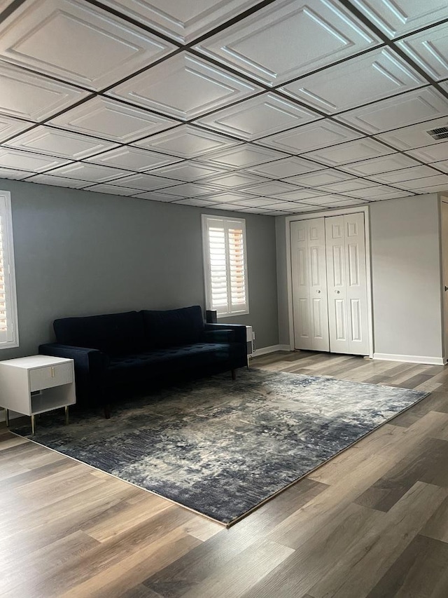 living room featuring visible vents, wood finished floors, baseboards, and an ornate ceiling