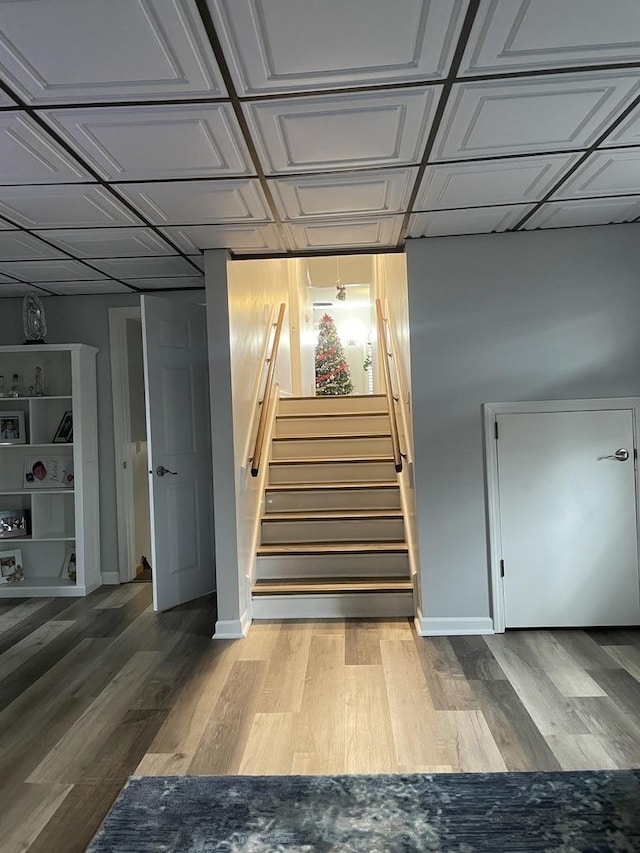 stairs featuring an ornate ceiling, baseboards, and wood finished floors