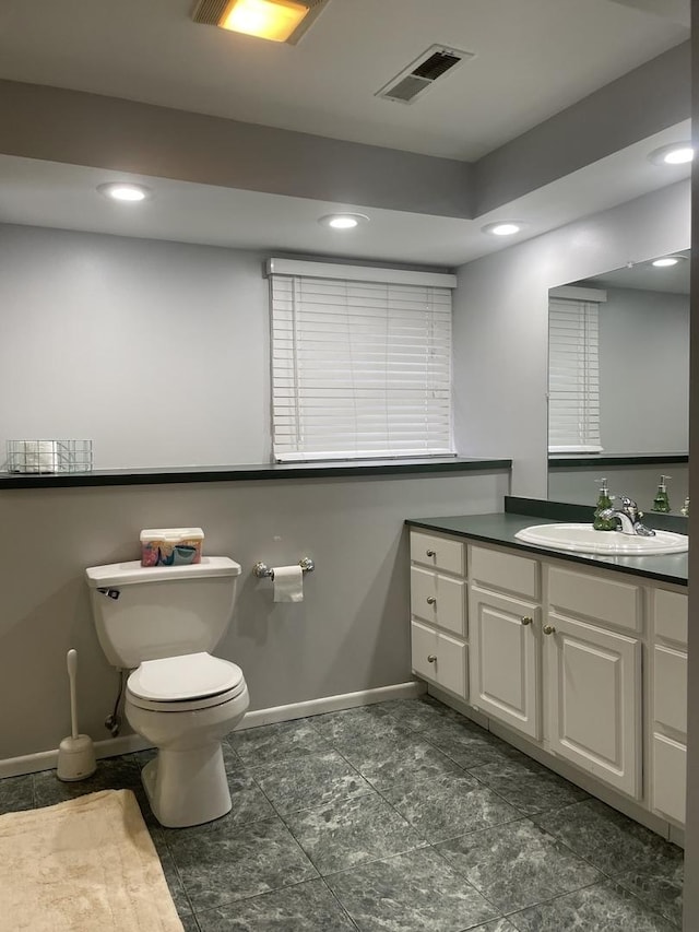 bathroom featuring visible vents, baseboards, toilet, recessed lighting, and vanity