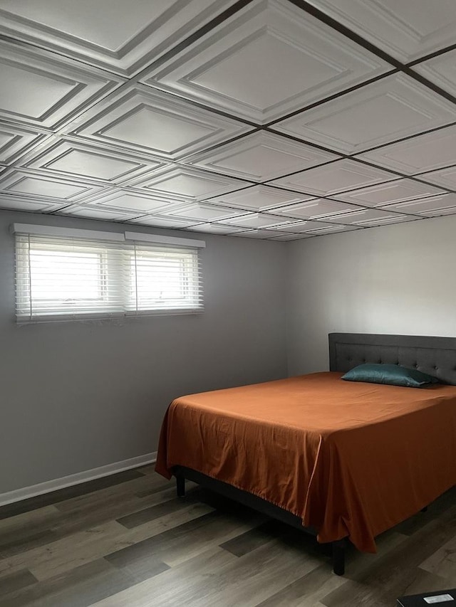 bedroom with baseboards, an ornate ceiling, and light wood finished floors