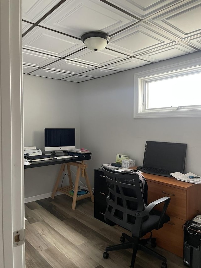 office area featuring an ornate ceiling, baseboards, and wood finished floors