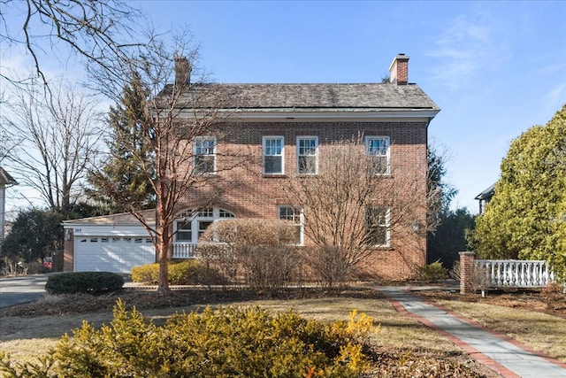 view of front facade featuring a garage, brick siding, and a chimney