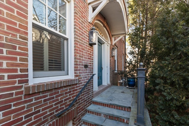 entrance to property featuring brick siding