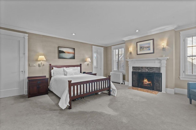 bedroom featuring a high end fireplace, radiator heating unit, carpet flooring, crown molding, and baseboards