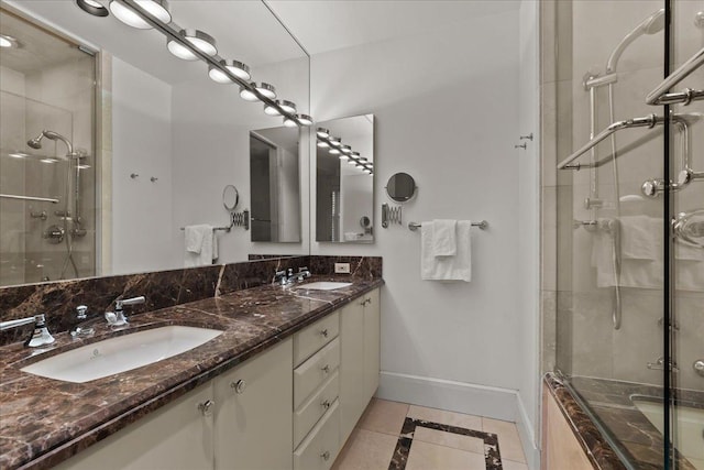 bathroom with a sink, baseboards, and a shower stall