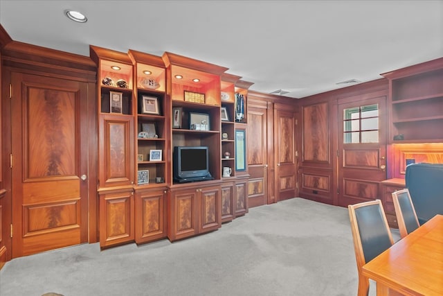 carpeted office space featuring recessed lighting, visible vents, and wood walls