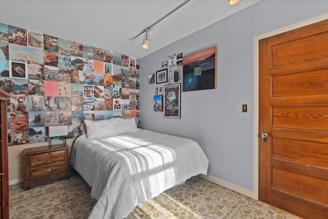 bedroom with baseboards and rail lighting