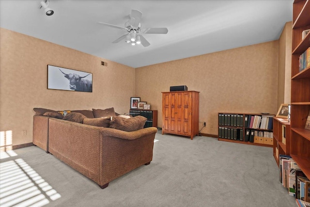 carpeted living area with baseboards, visible vents, wallpapered walls, and a ceiling fan