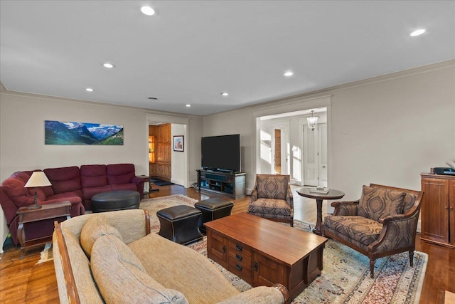 living room featuring recessed lighting, crown molding, and light wood-type flooring